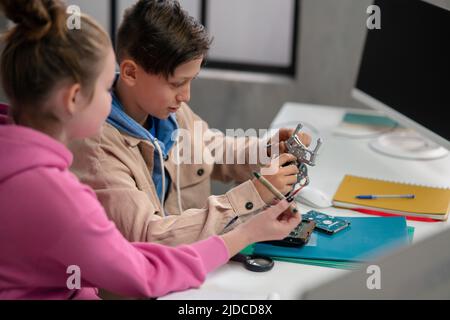 Pupils at school working with electronics component at robotics classroom. Stock Photo
