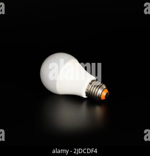 Economical LED light bulb with reflection on a black background Stock Photo
