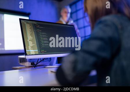 Rear view of schoolgirl using computer in classroom at school Stock Photo