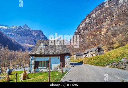 The beautiful mountain landscape with small stone houses and green lawn in the foreground, Sonogno, Valle Verzasca, Switzerland Stock Photo