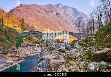 The Salt Bridge (Ponte degli Salti) and rocky Verzasca River in front of Pizzo di Vogorno Mount, Lavertezzo, Valle Verzasca, Switzerland Stock Photo