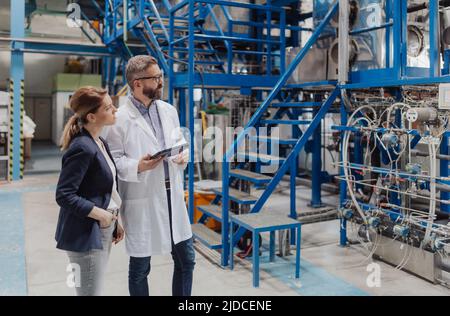 Engineering managers with tablet doing routine check up in industrial ...