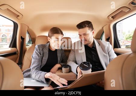 Man and woman discussing business project in car Stock Photo