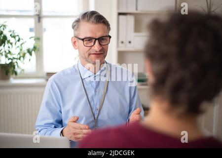Mature man recruiter explayining something young candidate during the job interview. Stock Photo