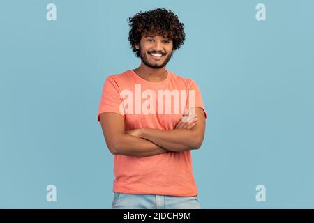 Cheerful handsome young eastern man on blue Stock Photo