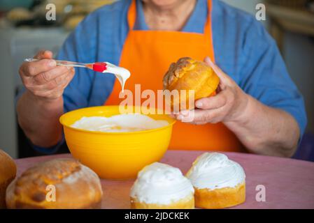 one grandmother smears Easter cake with protein cream Stock Photo