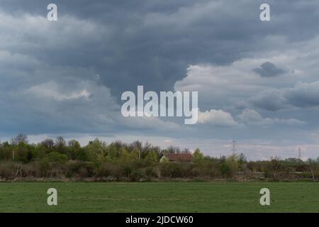 Funnel cloud above house in countryside, storm cloud in rural area Stock Photo
