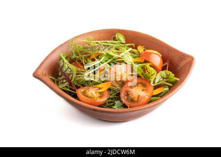 Vegetarian vegetables salad of tomatoes, marigold petals, microgreen sprouts isolated on white background. Side view, close up. Stock Photo