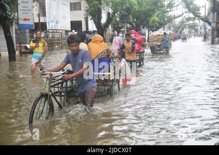 Sylhet, Bangladesh. 20th June 2022.  People traveling in rickshaws during floods. The worst flooding in nearly 20 years has ravaged parts of Bangladesh, leaving dozens of people dead and millions stranded. Stock Photo