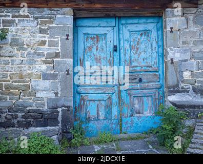 Blue door in the garden wall of a house in a Mountain village of Zagori Northern Greece Stock Photo