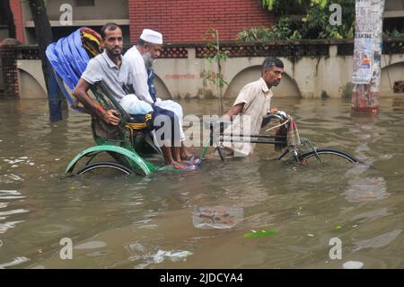 Sylhet, Bangladesh. 20th June 2022.  People traveling in rickshaws during floods. The worst flooding in nearly 20 years has ravaged parts of Bangladesh, leaving dozens of people dead and millions stranded. Stock Photo