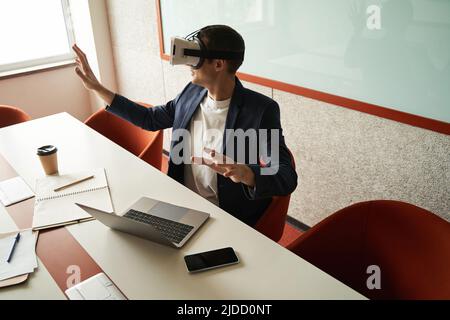 Man exploring office in virtual reality goggles Stock Photo