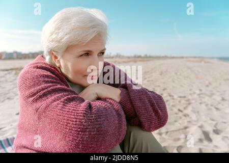 Beautiful gray-haired daydreaming by the sea Stock Photo