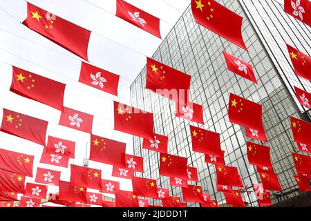 Hong Kong, China. 20th June, 2022. China's national flags and the Hong Kong Special Administrative Region (HKSAR) flags are hung above a street in Hong Kong, south China, June 20, 2022. This year marks the 25th anniversary of Hong Kong's return to the motherland. Credit: Wu Xiaochu/Xinhua/Alamy Live News Stock Photo