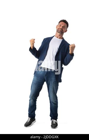 Confident mid adult businessman wearing blazer and jeans holding fists in air standing on white studio background Stock Photo