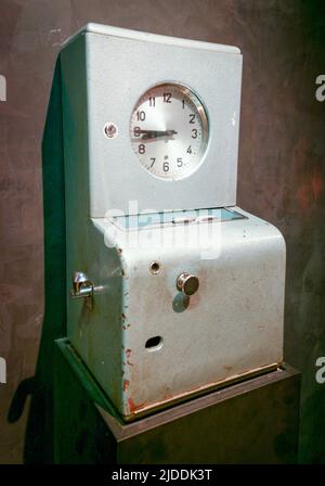 Vintage factory time / punch clock. A retro time clock / vintage punch clock is a device that records start and end times for hourly employees. Stock Photo