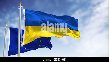 the national flag of Ukraine waving with blurred european union flag on a clear day. Democracy and politics. Stock Photo