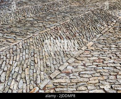 Courtyard stones are arranged in an interesting pattern at the castle in Serralunga. Stock Photo