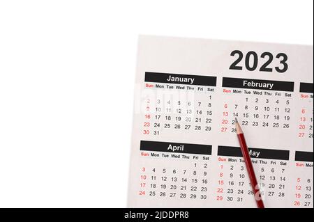 Close-Up Of Pencil On Calendar 2023. Close up of pencil on calendar on white using as writing agenda or important memo and appointment and planning on Stock Photo