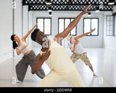 Portrait of smiling young dancing people practicing vigorous swing in studio Stock Photo