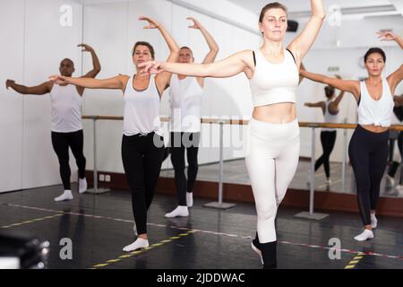 Concentrated women and men rehearsing ballet dance Stock Photo