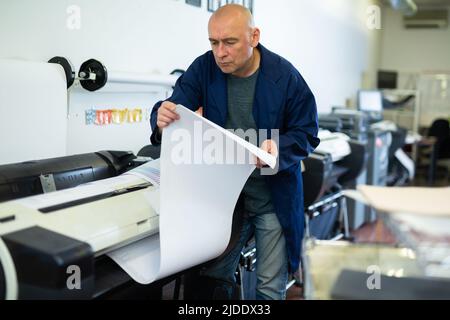 Man working in publishing facility Stock Photo