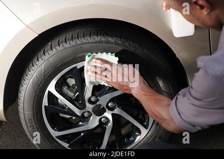 Close-up image driver cleaning aluminum wheels with soft cloth to make it shine Stock Photo