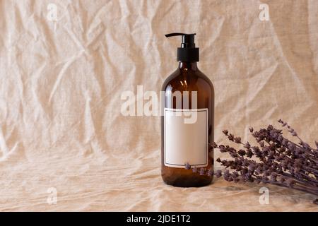 Empty amber glass soap or shampoo bottle on isolated background. Skin care or hair concept with natural cosmetics. Stock Photo