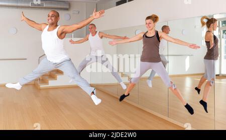 Positive young adults jumping during dance training Stock Photo