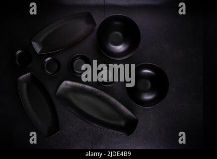 black plates and bowls on a black background Stock Photo