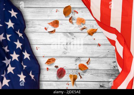 little flag of USA with maple leaves on wooden table. Above view. Stock Photo