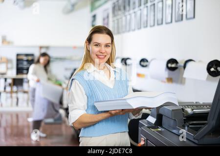 Technician working on plotter and cutter machine in printing shop Stock Photo