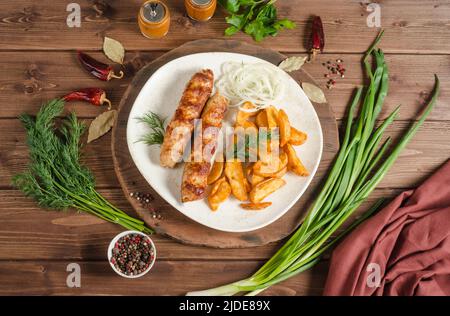 Meat lula kebab with onions and potatoes on a white plate on a dark wooden background, flat lay Stock Photo