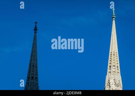 spires on St Patricks Cathedral in Manhattan NYC. One in the shade and on in the sun view Stock Photo