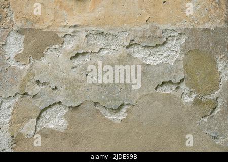 Small area of heavily flaking plaster on a stone wall Stock Photo