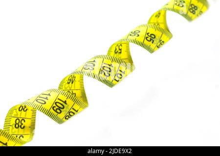 Spiral of yellow and black measuring tape isolated on white background close-up Stock Photo
