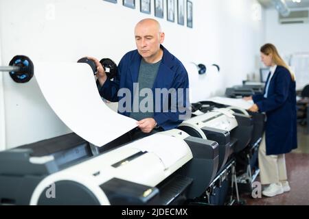 Man working in publishing facility Stock Photo