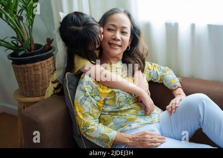 Asian portrait, grandma and granddaughter doing leisure activities and hugging to show their love and care for each other Stock Photo