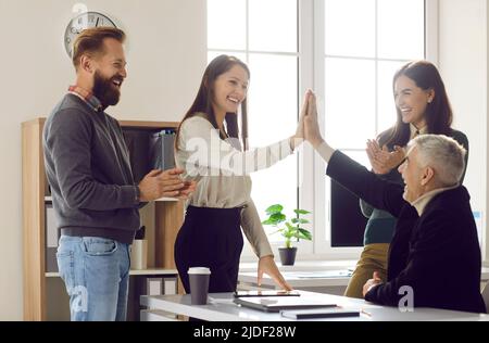 Smiling colleagues give high five celebrate win Stock Photo