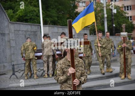 Lviv, Ukraine. 17th June, 2022. Ukrainian military hold crosses and the Ukrainian flag during the farewell ceremony of the fallen soldiers. Funeral ceremony of senior lieutenant Serhiy Spodarenko and junior sergeant Ivan Kerdman, who died in battle with Russian troops in Lviv. Credit: SOPA Images Limited/Alamy Live News Stock Photo