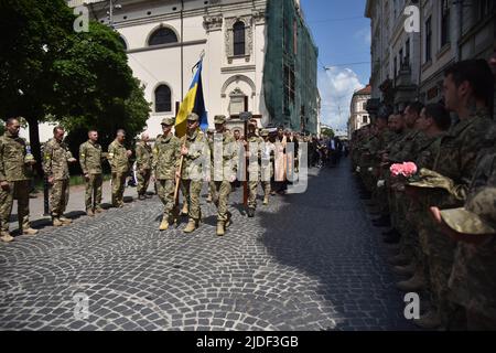 Lviv, Ukraine. 17th June, 2022. Soldiers march with the Ukrainian flag during the farewell ceremony of the fallen soldier. Funeral ceremony of senior lieutenant Serhiy Spodarenko and junior sergeant Ivan Kerdman, who died in battle with Russian troops in Lviv. Credit: SOPA Images Limited/Alamy Live News Stock Photo