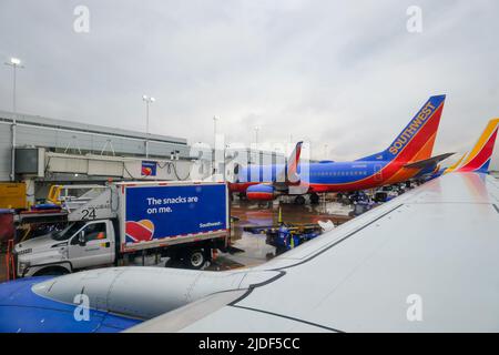 Stock images of South West Airlines at gate with plane support vehicles. Luggage and ground crew. Stock Photo