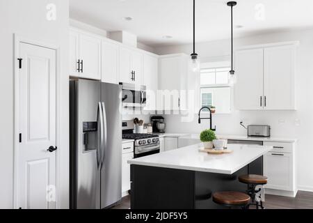 A modern farmhouse kitchen with white cabinets, a wood island with chairs,  Viking stainless steel appliances, and a dark granite countertop Stock  Photo - Alamy