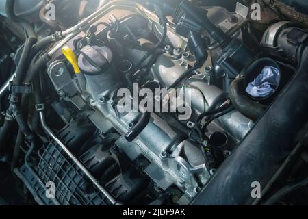 Modern turbo engine in process of changing spark plugs. Interval replacement of consumables and car maintenance. Stock Photo