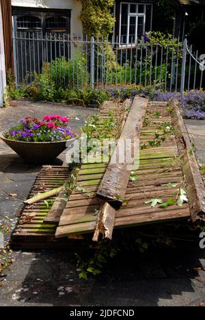Remnants of old domestic garden fence stacked in front of house while awaiting collection for disposal Stock Photo
