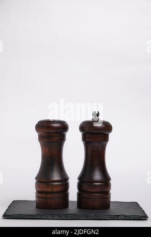 Pepper shaker and salt shaker on slate stone on white background Stock Photo