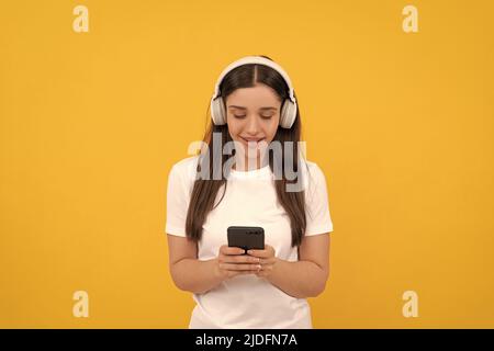 happy lady in white shirt listening music in headphones and chatting on phone, music Stock Photo