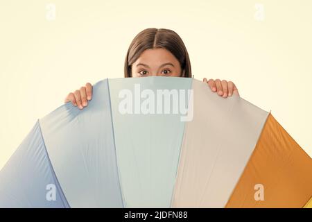 kid behind multicolored rain protection parasol isolated on white background, weather forecast. Stock Photo