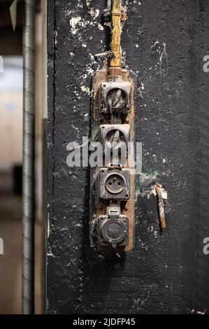 Anderlecht, Brussels Capital Region, Belgium - 06 11 2022 - Worn power switches on a rough wall Stock Photo