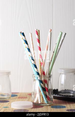 Colorful Paper Straws on White Wooden Background. Event and Party Supplies. Selective Focus. Copy Space Stock Photo